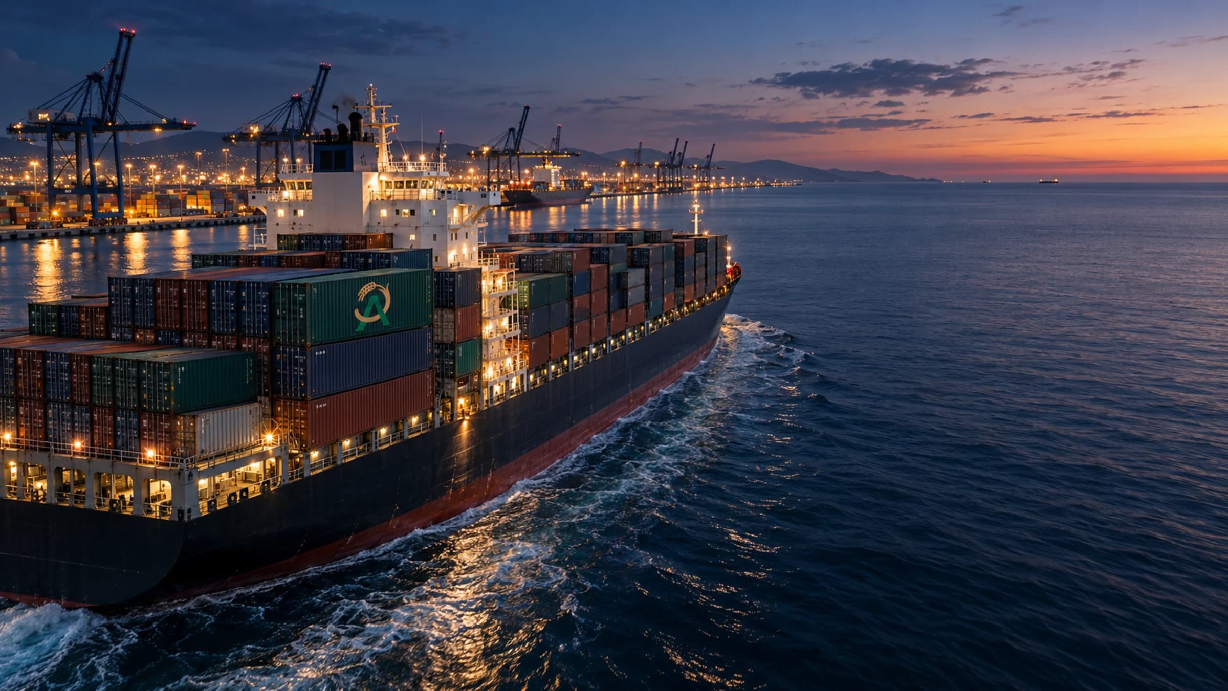 A loaded container vessel departing port at dusk